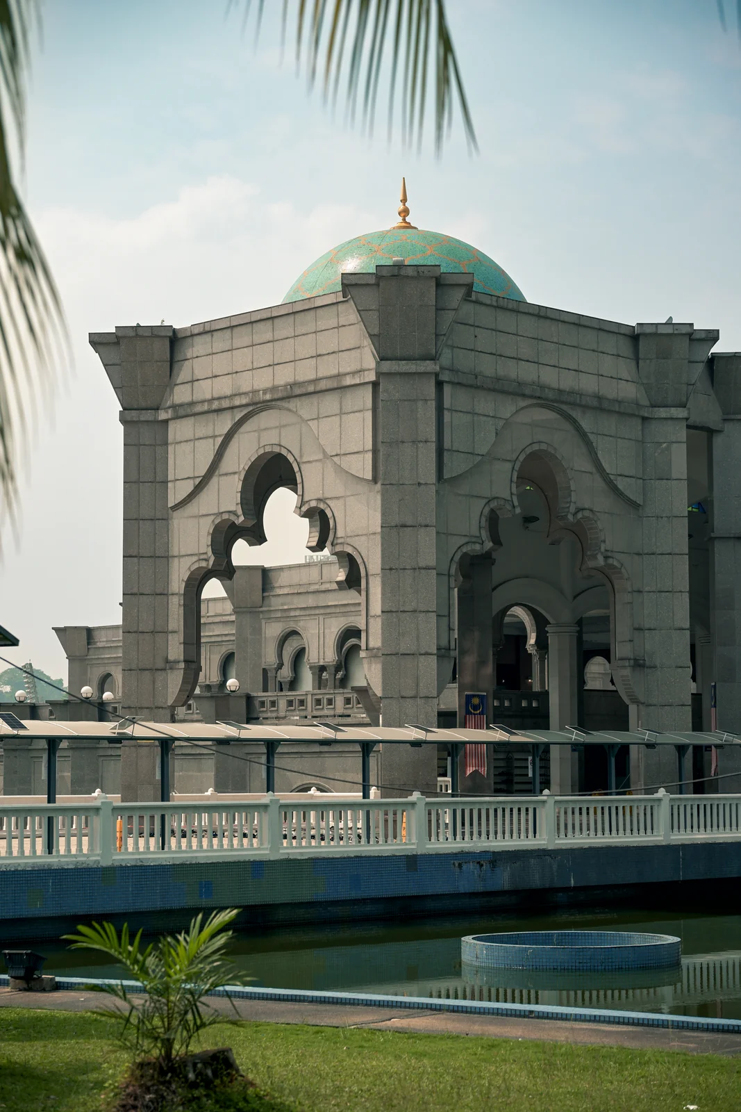 Federal Territory Mosque carved stone arches reflecting in tranquil courtyard pool