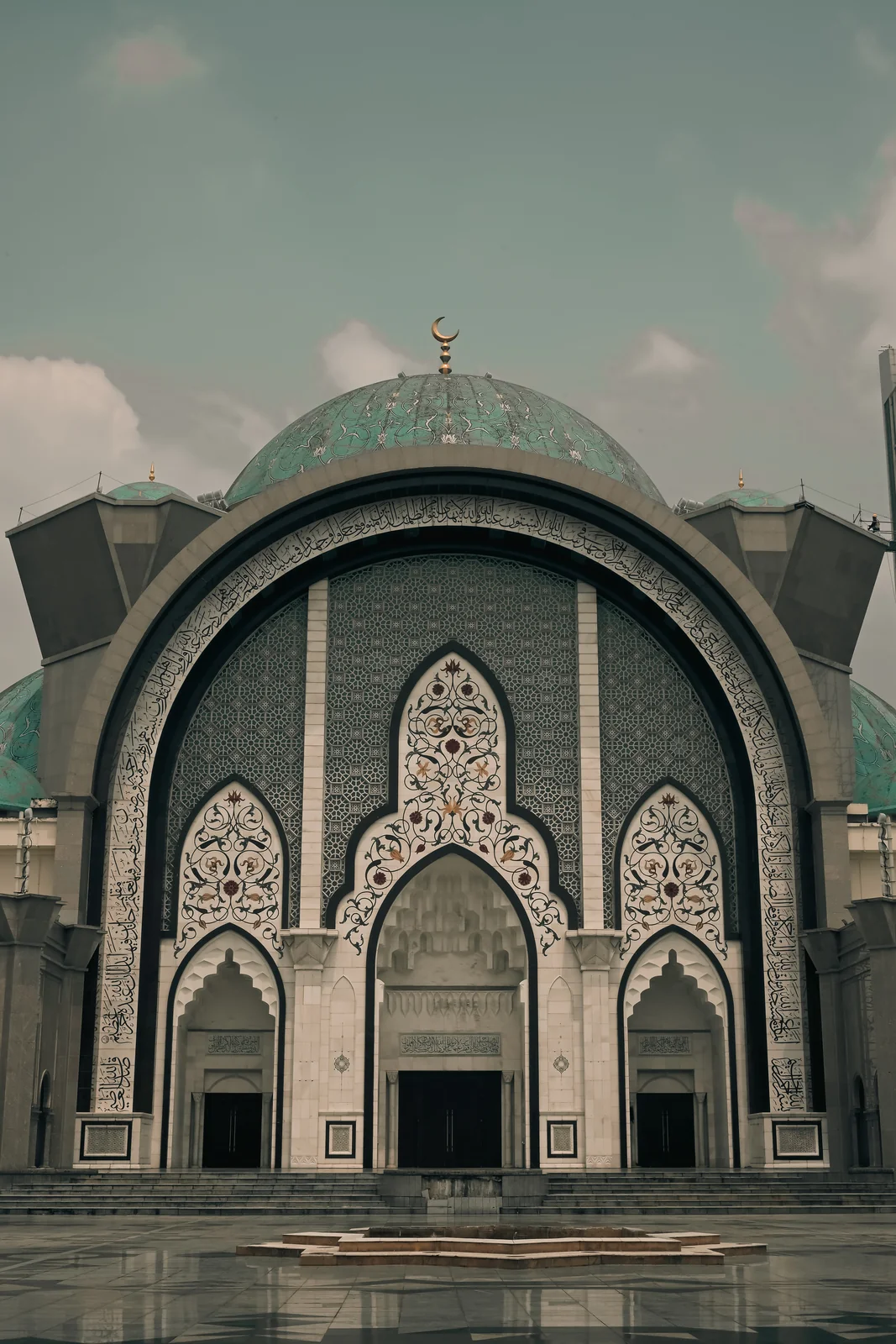 Grand central archway entrance adorned with intricate Islamic geometric motifs