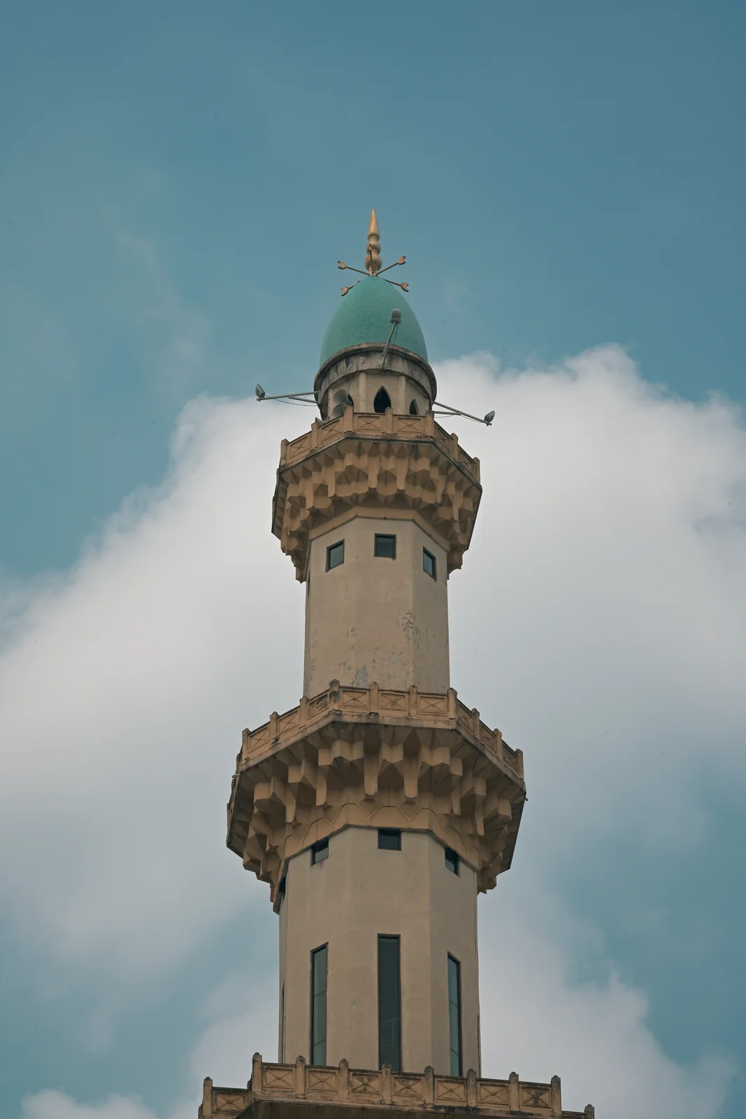 Slender Ottoman-style minaret tower rising into the tropical sky