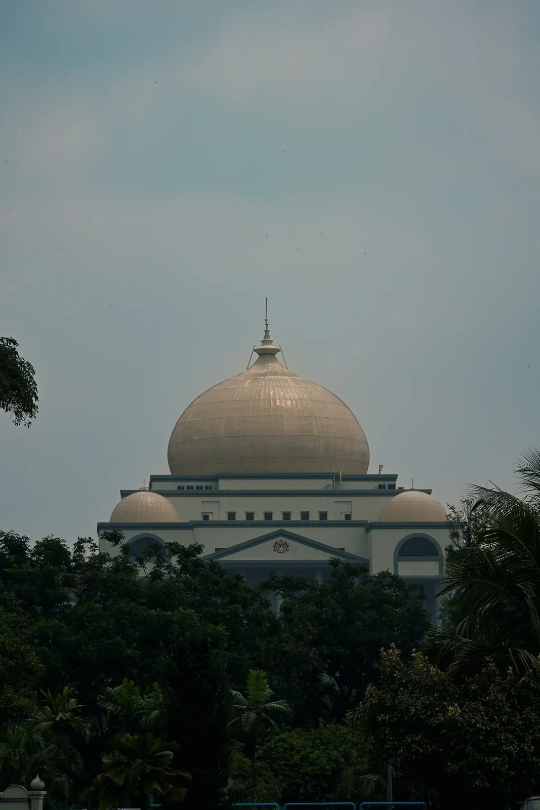 Mosque dome silhouette gracefully framed by lush tropical foliage