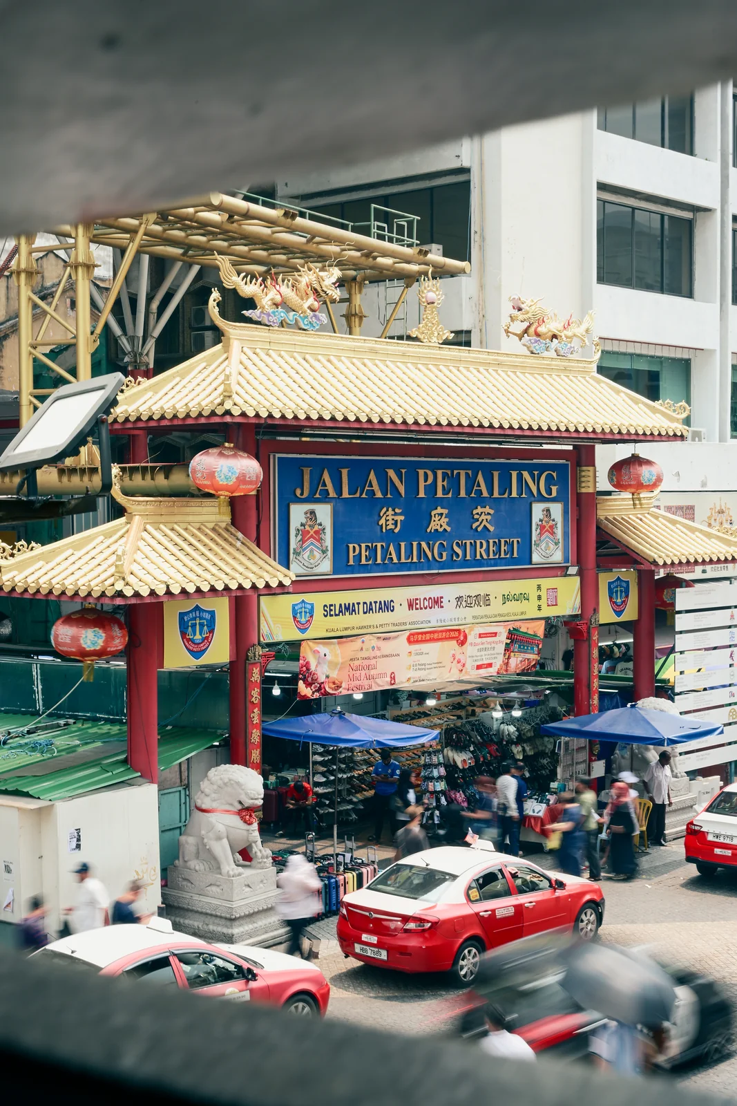 Jalan Petaling Chinatown grand entrance archway with red taxis