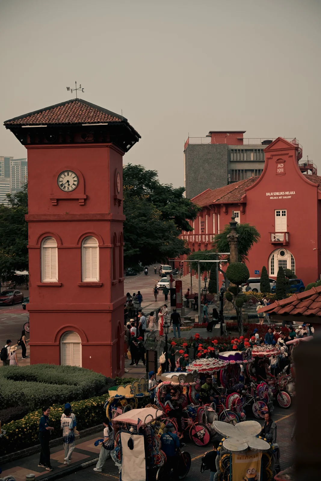 Red Square colonial clock tower surrounded by colorful decorated trishaws