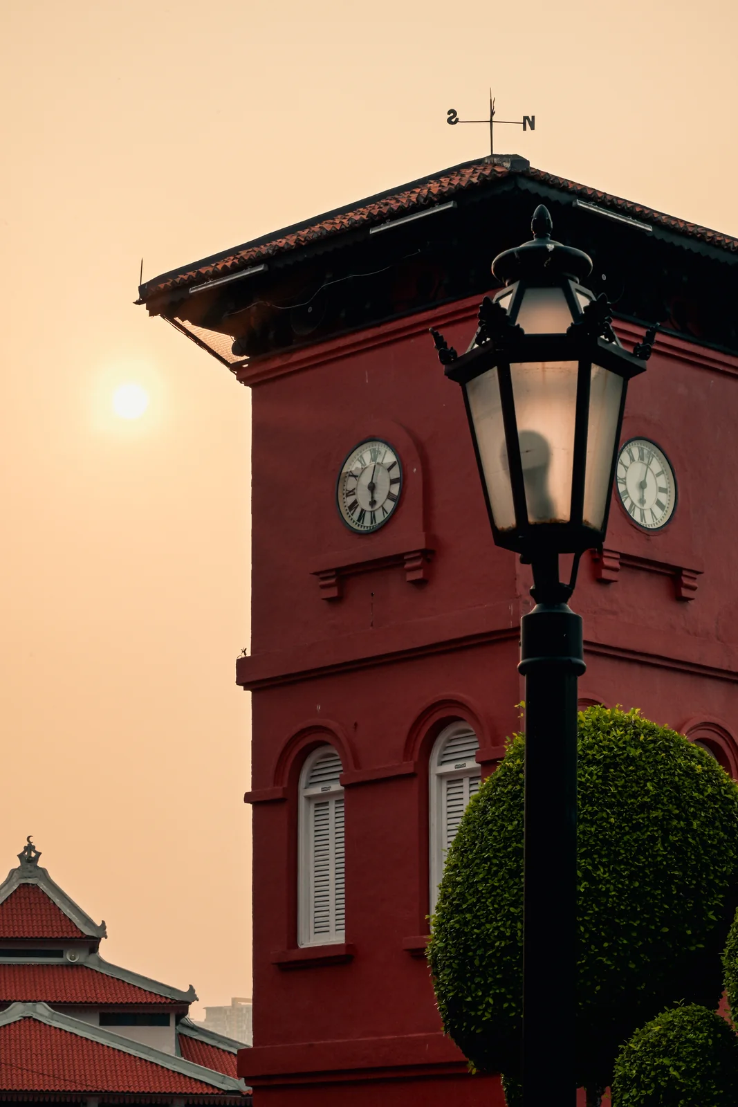 Colonial clock tower and vintage street lamp bathed in warm late afternoon sun
