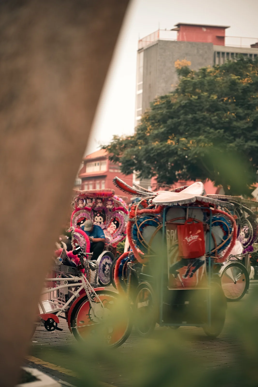 Colorful flower-decorated Malacca trishaw framed by tropical greenery