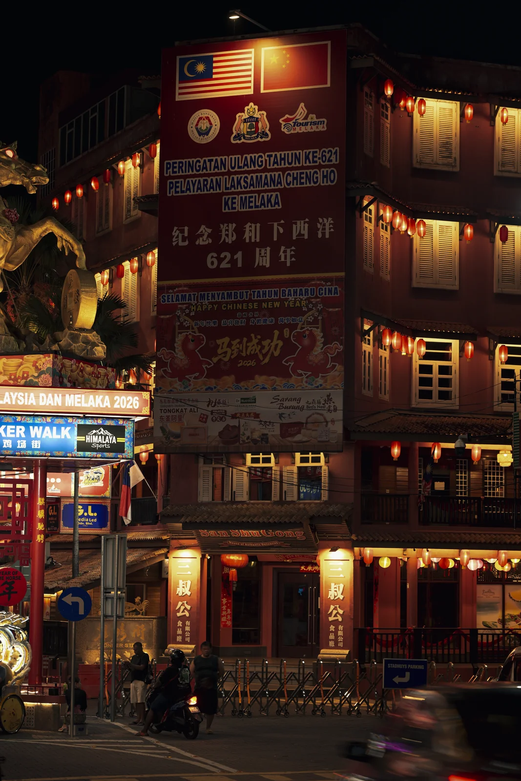 Historic riverside wooden shophouses glowing warmly in lantern light