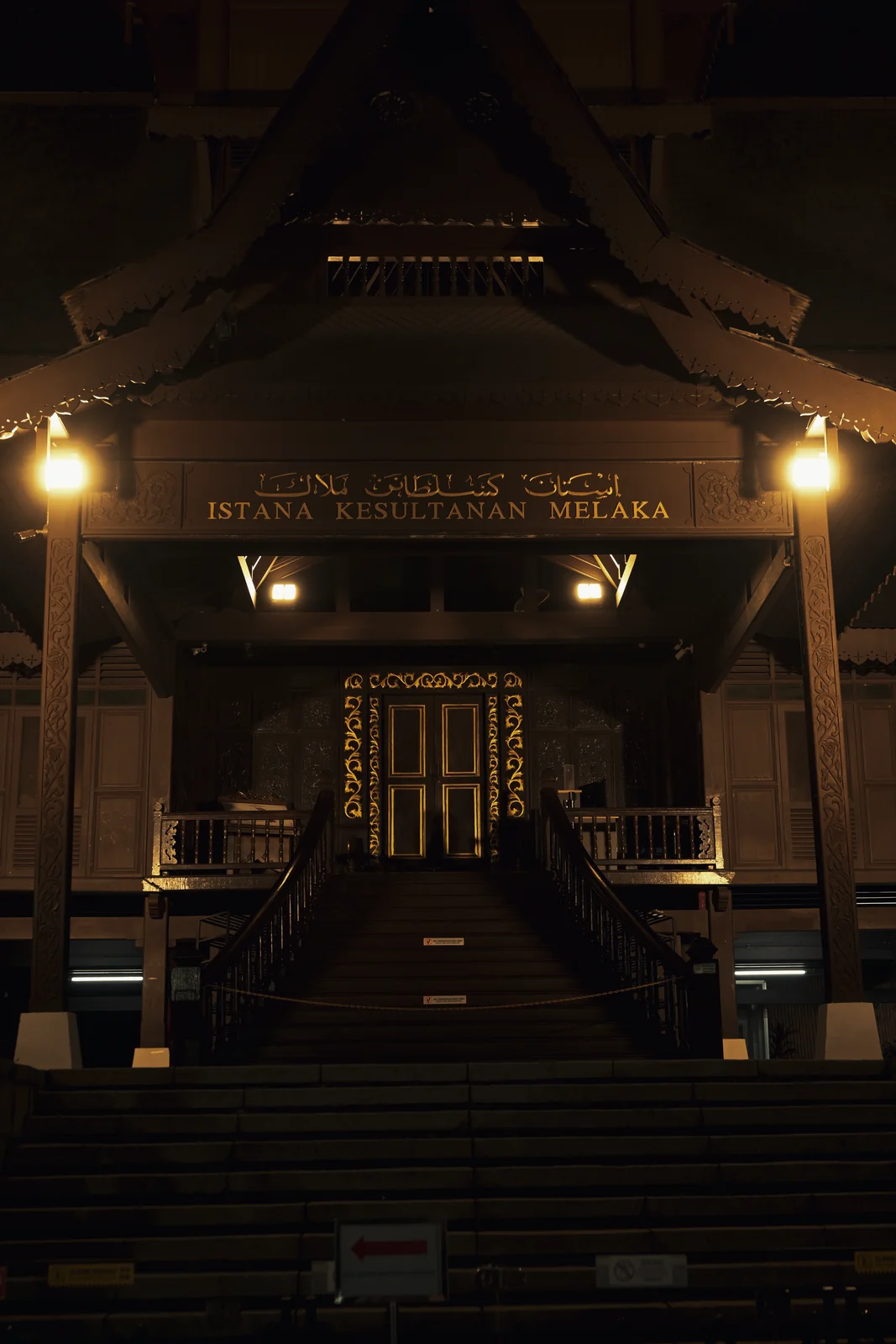 Traditional temple entrance and ornate pillars illuminated at night