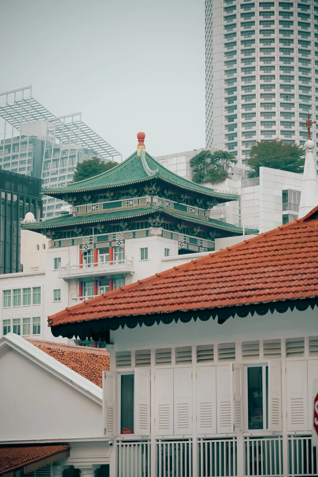 Traditional temple tiered eaves overlooking historic Chinatown shophouses