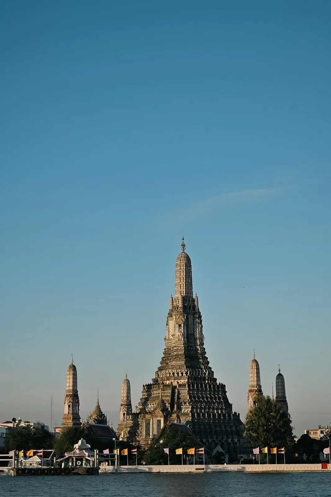 Wat Arun prang towering majestically across the Chao Phraya River, Bangkok