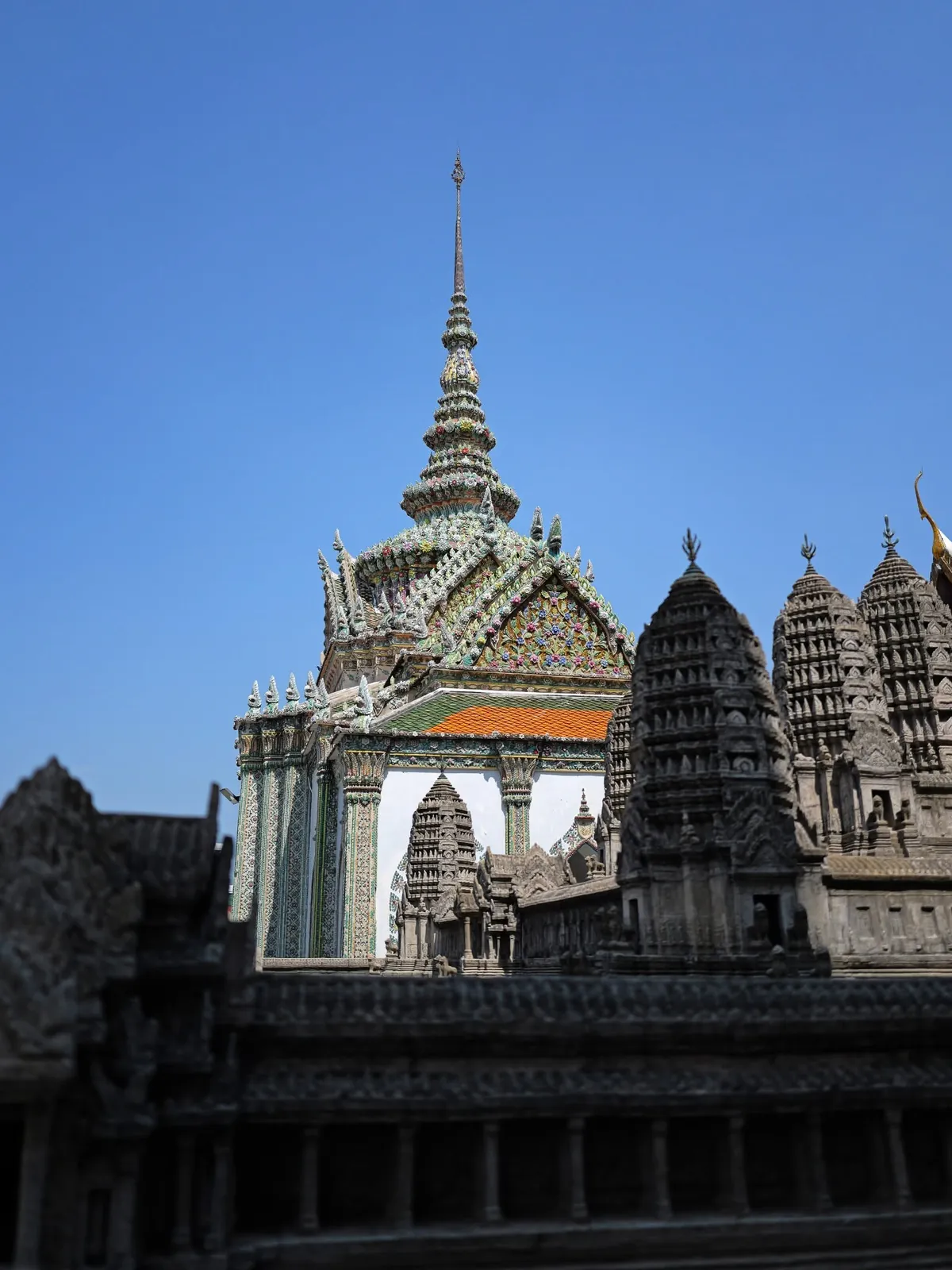 Intricate multi-tiered temple spires and architecture at the Grand Palace, Bangkok