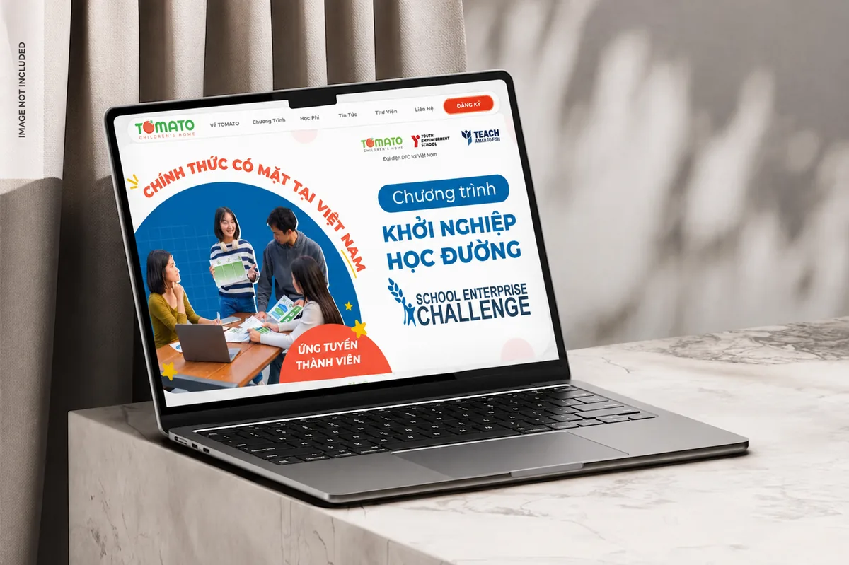 TOMATO Children's Home website shown on a laptop in a warm studio scene